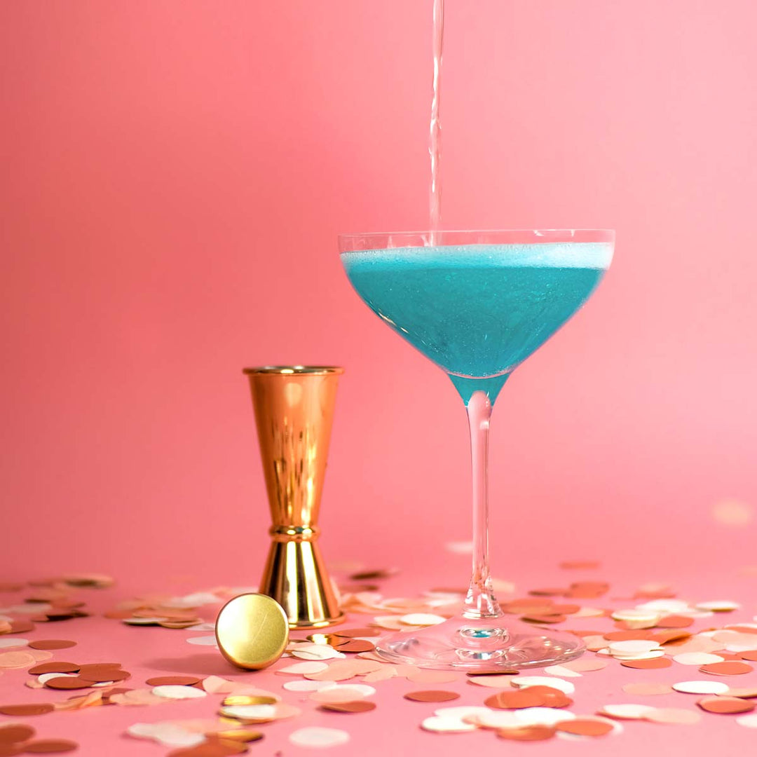 Das Glas mit Flaschenpost Gin und Zuckerwatte wird mit Sekt aufgefüllt für den perfekten Silvester Drink