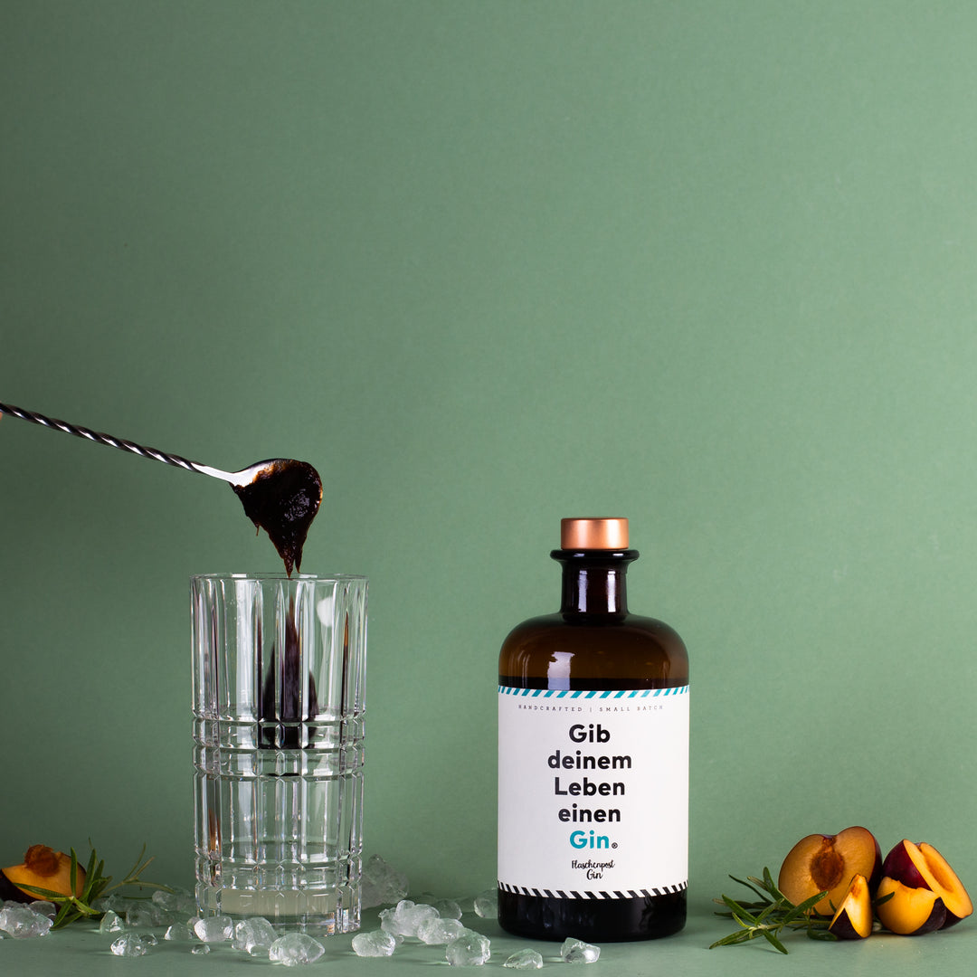Pflaumenmus wird in das Cocktail Glas hinzugegeben für das Rezept Pfläumchen Träumchen mit dem Gin: Gib deinem Leben einen Gin von Flaschenpost Gin