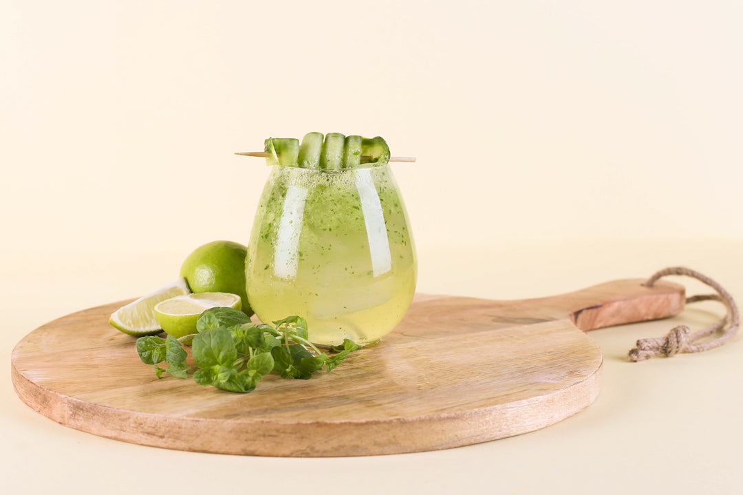 Perfekter Sommerdrink, mit Flaschenpost Gin, Muntere Minze im Glas dekoriert mit Limetten, Gurke und Minze