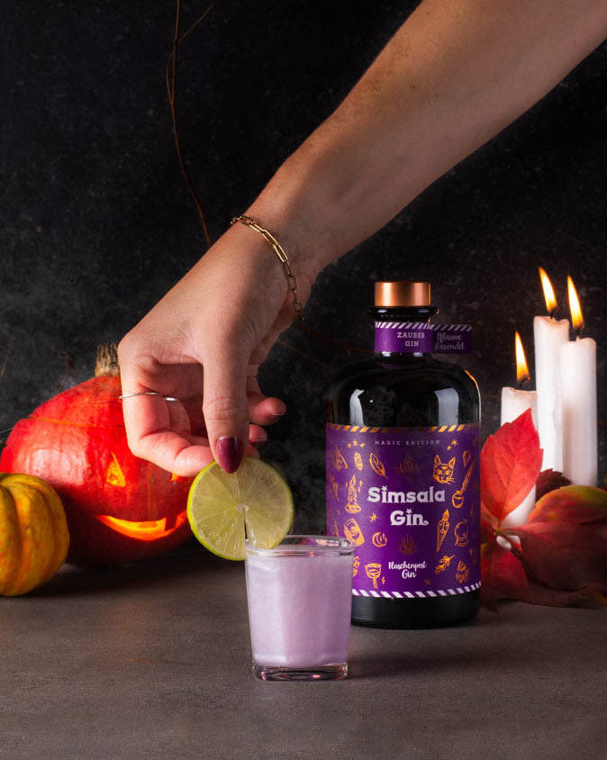 Der Drink wird zum Schluss mit Limette garniert für unser Halloween Rezept "Glitzer Spritzer" mit der Simsala Gin Magic Edition mit Farbwechsel