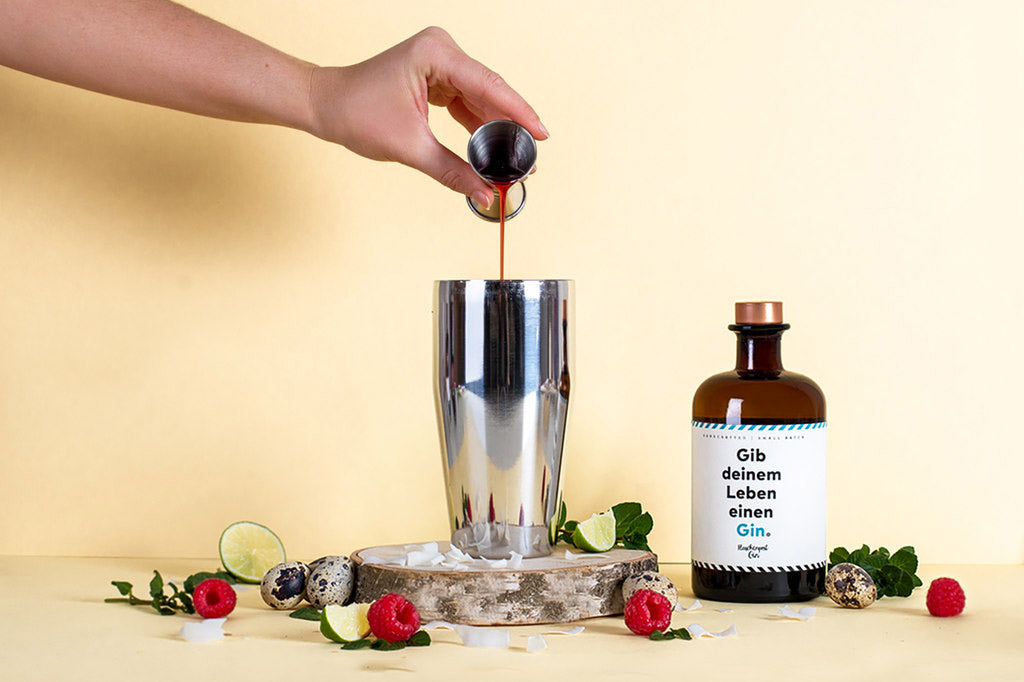 In den Shaker wird Sirup zum Flaschenpost Gin hinzugegeben für den perfekten Oster Drink