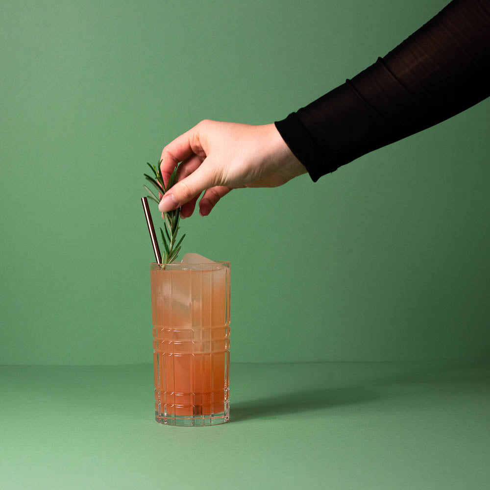 Der fertige Drink Frischekick mit Flaschenpost Gin wird mit Rosmarin garniert