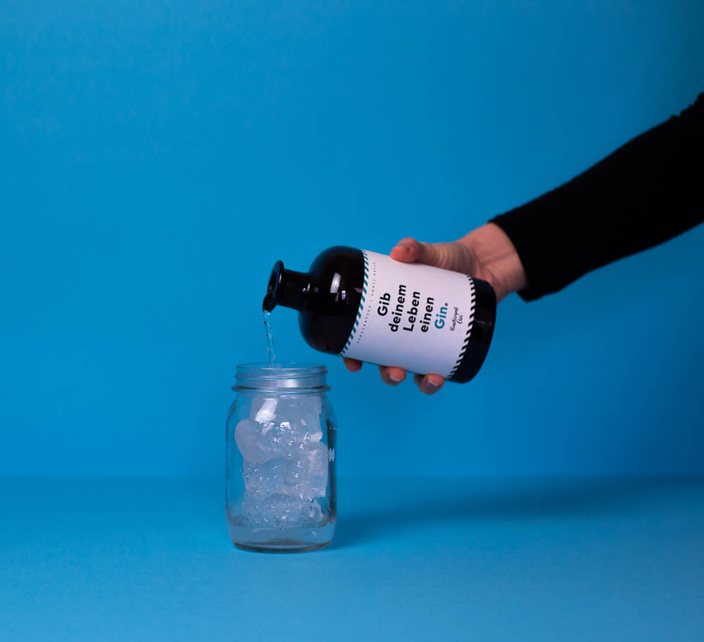 Gib deinem Leben einen Gin von Flaschenpost Gin wird in ein Glas mit Eiswürfeln geschüttet für den perfekten Osterdrink Möhrchen mit Öhrchen