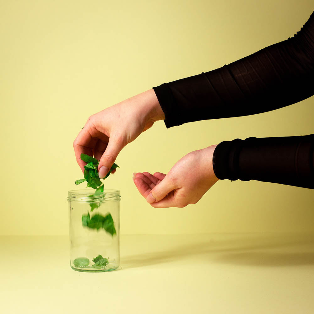 Minze wird in das Glas gegeben für den perfekten Valentinstag Drink mit Flaschenpost Gin