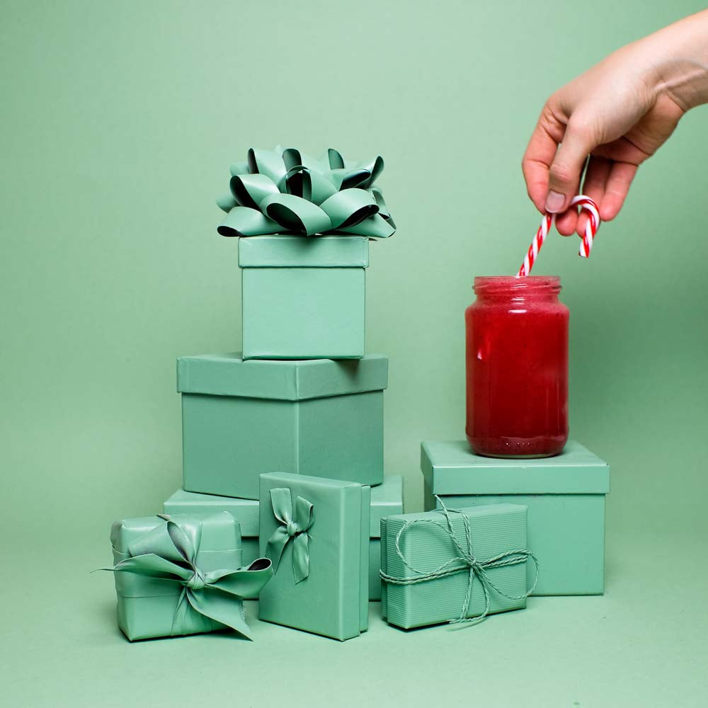 Perfekter Winterdrink Cocktail mit Flaschenpost Gin wird mit einem Peppermint Stick verziert
