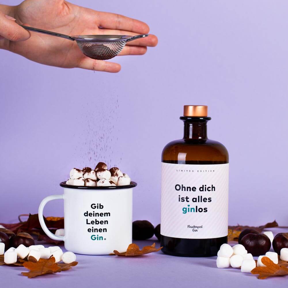 Kakaopulver wird durch ein Sieb über die Marshmallows gestreut für den einen wärmenden Drink in den kalten Tagen mit dem Flaschenpost Gin: Ohne dich ist alles ginlos