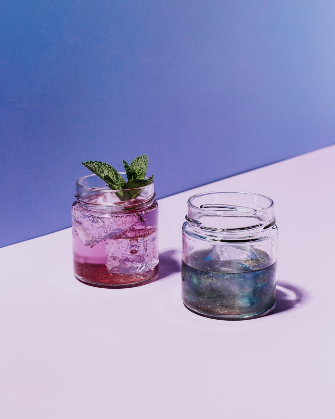 Unser glitzernder Simsala Gin einmal pur und in magisch blauer Farbe und einmal in einem anderen Glas als Gin Tonic, wodurch er seine Farbe zu einem zauberhaften lila gewechselt hat.