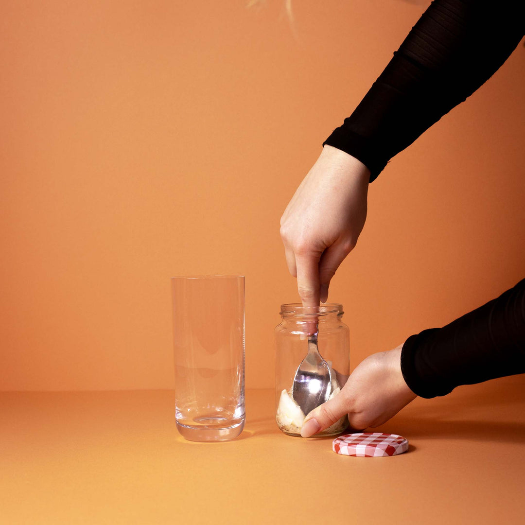 Fenchelscheiben werden im Cocktail Glas mit einem Löffel zerdrückt für den perfekten Sommer Drink mit Flaschenpost Gin