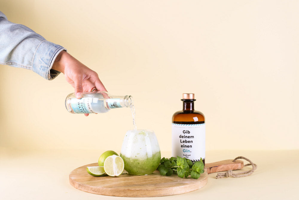 Tonic Water wird in das Cocktail Glas gefüllt für den leckeren Sommerdrink Muntere Minze mit Flaschenpost Gin