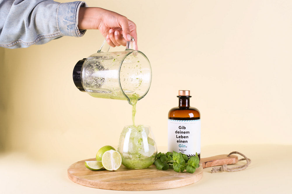 Für den perfekten Sommerdrink mit Flaschenpost Gin wird der Inhalt des Mixers nun in das mit Eiswürfeln gefüllte Glas gegeben