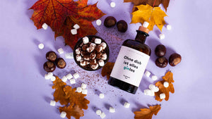 Warm ums Herz Drink mit Flaschenpost Gin verziert mit Herbstblättern, Kastanien und Marshmallows 