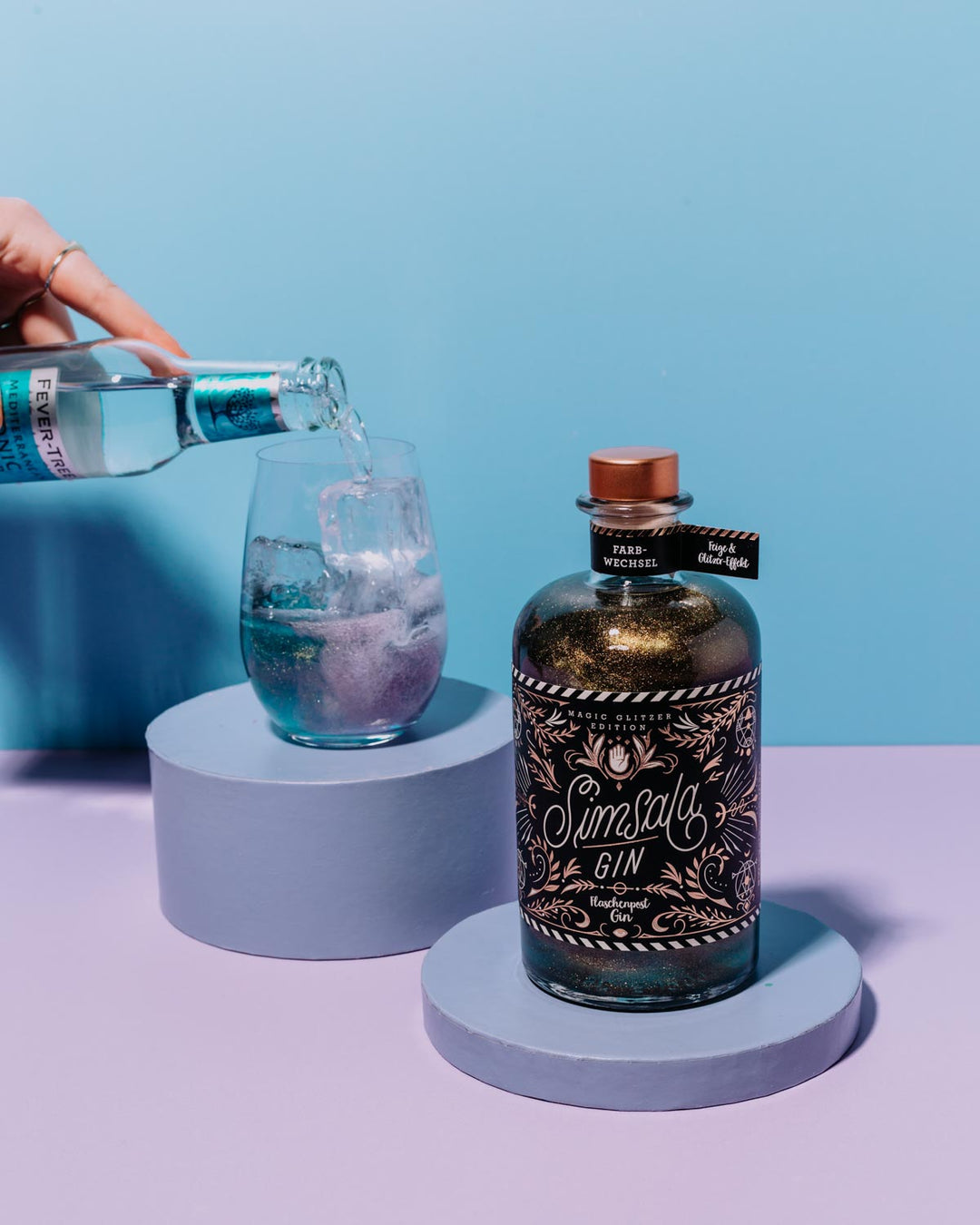 Unser Simsala Gin zeigt seinen magischen Farbwechsel, wenn er mit Tonic Water gemischt wird, was die Farbe des glitzernden Gins von blau zu lila verändert.