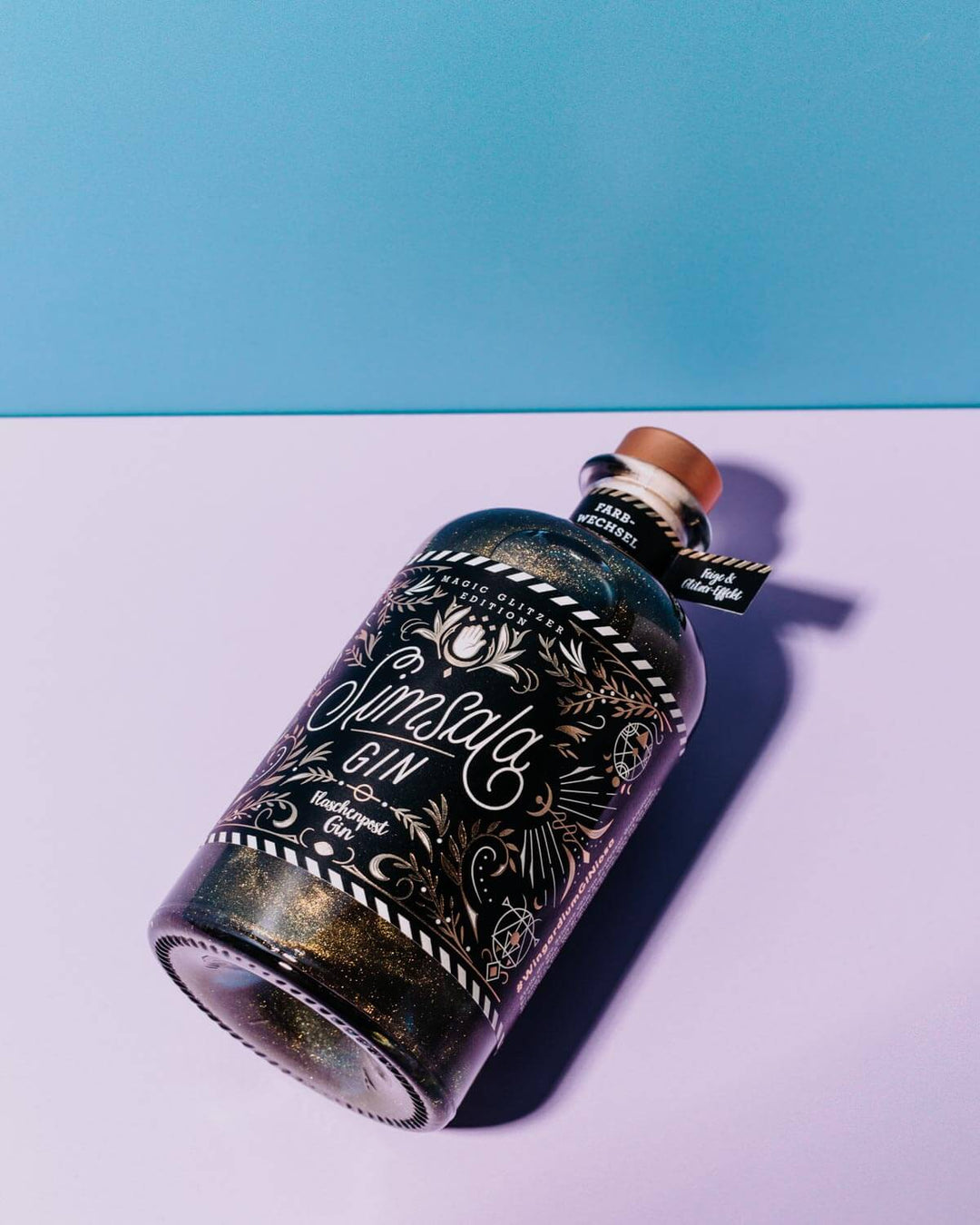 Das Etikett des Simsala Gins von Flaschenpost Gin ist ein wahrhaft magisches Kunstwerk mit goldenen Details auf schwarzem Hintergrund, das vom Special Artist Nim Ben-Reuven aus New York kreiert wurde.