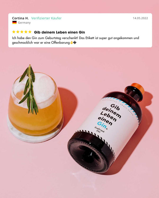 "Gib deinem Leben einen Gin" von Flaschenpost Gin neben einem Gin Tonic und der 5 Sterne Kundenbewertung "Ich habe den Gin zum Geburtstag verschenkt! Das Etikett ist super gut angekommen und geschmacklich war eine Offenbarung. "